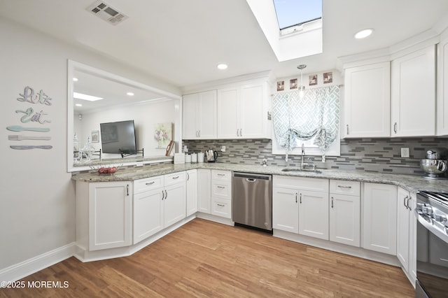 25 Tropicana Ct, Toms River, NJ 08757 - kitchen with appliances with stainless steel finishes, a skylight, decorative backsplash, white cabinets, and recessed lighting