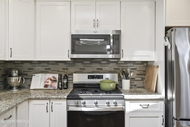 25 Tropicana Ct, Toms River, NJ 08757 - kitchen with appliances with stainless steel finishes, white cabinetry, tasteful backsplash, and light stone counters