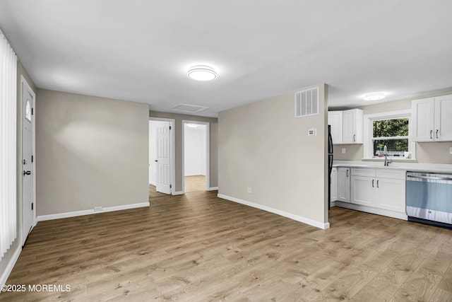 9 Frederick Dr, Bayville, NJ 08721 - kitchen with stainless steel dishwasher, light countertops, light wood-style flooring, white cabinetry, and open floor plan