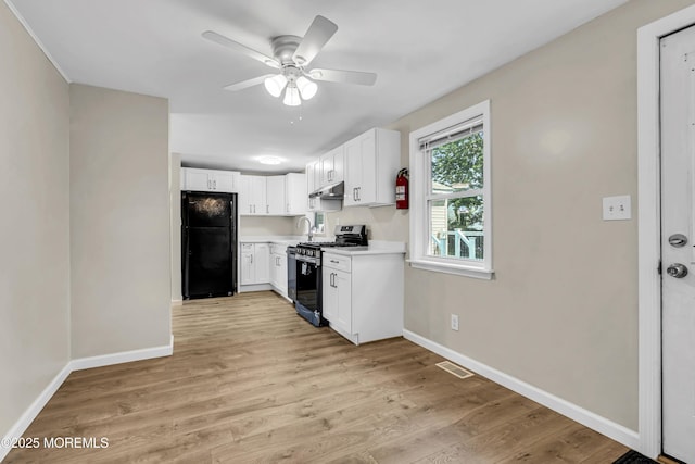 9 Frederick Dr, Bayville, NJ 08721 - kitchen featuring stainless steel gas range oven, freestanding refrigerator, under cabinet range hood, ceiling fan, and light wood-style flooring