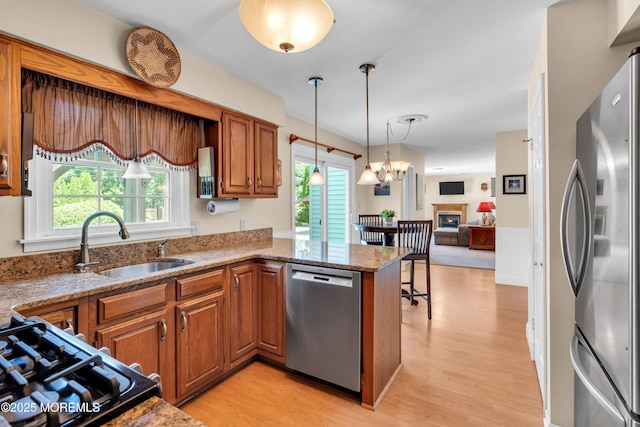 627 Meadow Run, Brick, NJ 08724 - kitchen with stainless steel appliances, brown cabinets, light wood-style floors, and light stone countertops