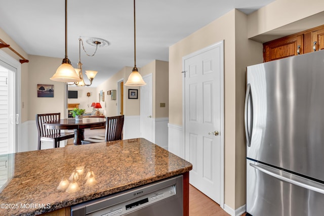 627 Meadow Run, Brick, NJ 08724 - kitchen featuring stainless steel appliances, brown cabinets, wainscoting, light wood-type flooring, and pendant lighting