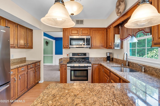 627 Meadow Run, Brick, NJ 08724 - kitchen featuring appliances with stainless steel finishes, light stone countertops, brown cabinets, and light wood-type flooring