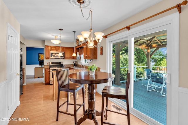 627 Meadow Run, Brick, NJ 08724 - dining area with wainscoting, a decorative wall, light wood finished floors, and a chandelier