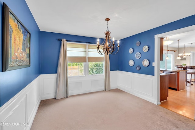 627 Meadow Run, Brick, NJ 08724 - unfurnished room with a chandelier, light colored carpet, healthy amount of natural light, wainscoting, and a decorative wall