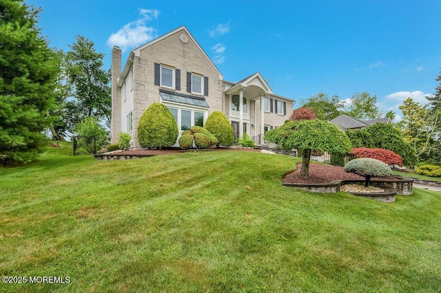 6 Opatut Ct, Morganville, NJ 07751 - view of front of home with a front yard, a chimney, and brick siding