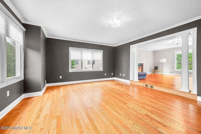 6 Opatut Ct, Morganville, NJ 07751 - unfurnished living room featuring ornate columns, wood finished floors, crown molding, and a glass covered fireplace