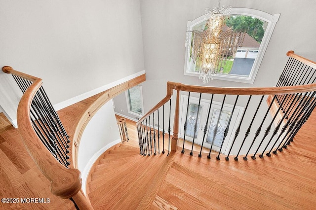 6 Opatut Ct, Morganville, NJ 07751 - staircase featuring a chandelier, a high ceiling, and wood finished floors