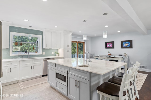 5 Maplecrest Ct, Toms River, NJ 08753 - kitchen with stainless steel dishwasher, built in microwave, a kitchen island with sink, decorative backsplash, and recessed lighting