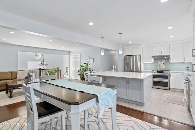 5 Maplecrest Ct, Toms River, NJ 08753 - kitchen featuring stainless steel appliances, under cabinet range hood, light countertops, a kitchen island with sink, and white cabinets