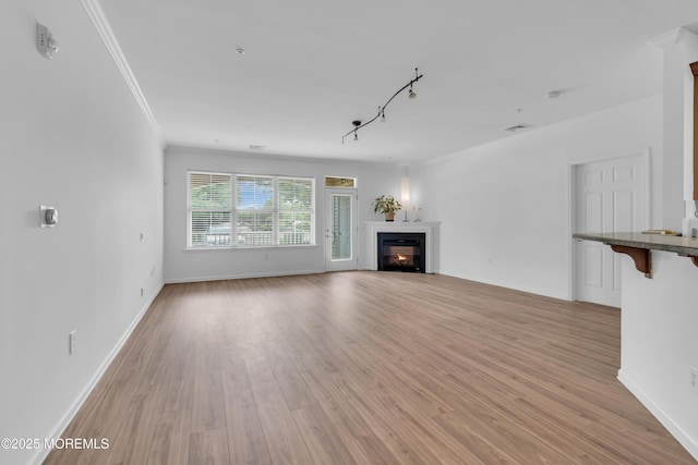 215 Sloan Ct, Matawan, NJ 07747 - unfurnished living room featuring ornamental molding, a glass covered fireplace, and light wood-type flooring