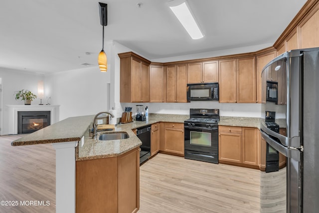 215 Sloan Ct, Matawan, NJ 07747 - kitchen featuring black appliances, a peninsula, light wood-style flooring, light stone counters, and open floor plan