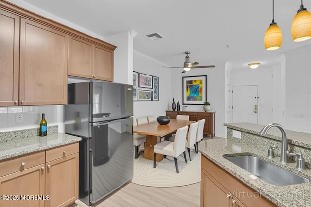 215 Sloan Ct, Matawan, NJ 07747 - kitchen featuring freestanding refrigerator, light wood finished floors, ceiling fan, decorative light fixtures, and light stone counters