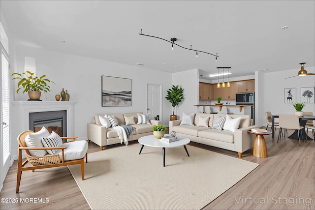 215 Sloan Ct, Matawan, NJ 07747 - living area featuring light wood-style flooring and a glass covered fireplace