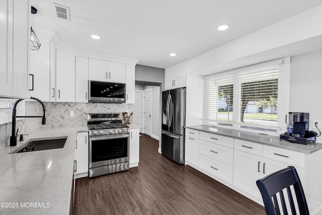 8 Blueberry Path, Howell, NJ 07731 - kitchen featuring stainless steel appliances, light stone countertops, tasteful backsplash, dark wood-style floors, and white cabinets