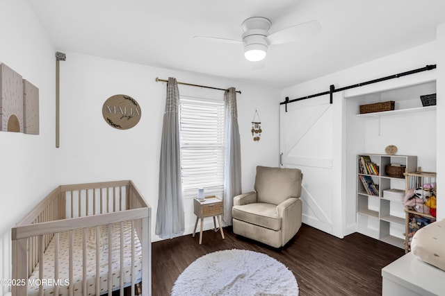 8 Blueberry Path, Howell, NJ 07731 - bedroom with a barn door, a crib, wood finished floors, and a ceiling fan