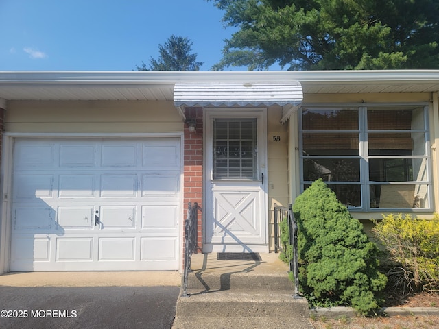 5B Lenape Dr, Whiting, NJ 08759 - view of exterior entry featuring brick siding and an attached garage