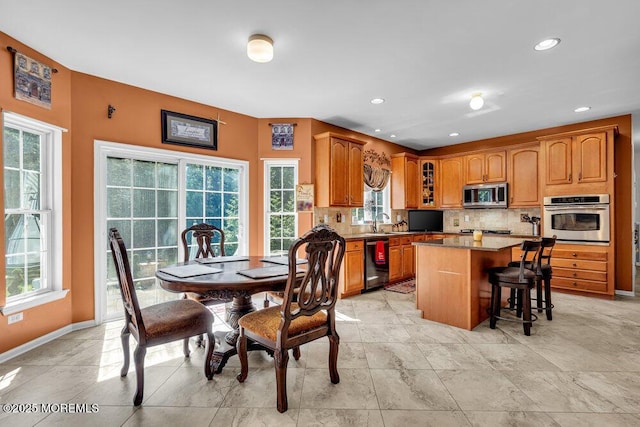 1 Opal Ct, Jackson, NJ 08527 - kitchen with appliances with stainless steel finishes, glass insert cabinets, decorative backsplash, a breakfast bar area, and a kitchen island