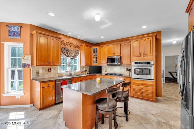 1 Opal Ct, Jackson, NJ 08527 - kitchen with appliances with stainless steel finishes, glass insert cabinets, a kitchen bar, decorative backsplash, and a center island