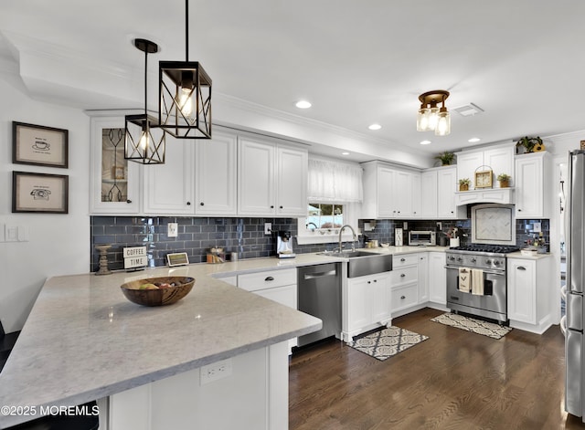 141 Twin Rivers Dr, Toms River, NJ 08753 - kitchen with stainless steel appliances, a peninsula, ornamental molding, white cabinets, and dark wood finished floors