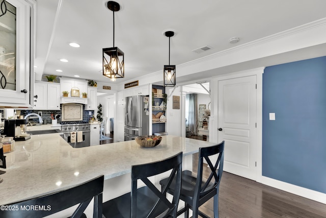 141 Twin Rivers Dr, Toms River, NJ 08753 - kitchen with appliances with stainless steel finishes, a peninsula, light stone countertops, dark wood-style floors, and backsplash