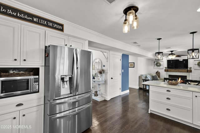 141 Twin Rivers Dr, Toms River, NJ 08753 - kitchen with appliances with stainless steel finishes, ceiling fan, a warm lit fireplace, dark wood finished floors, and white cabinets