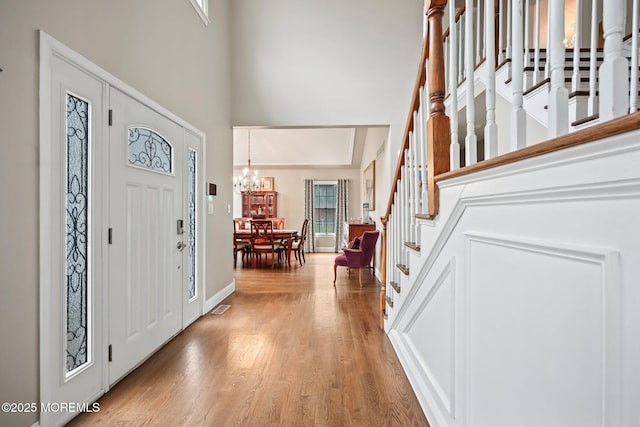 2 Independence Dr, Aberdeen, NJ 07747 - foyer entrance featuring a high ceiling, stairway, light wood finished floors, and a chandelier