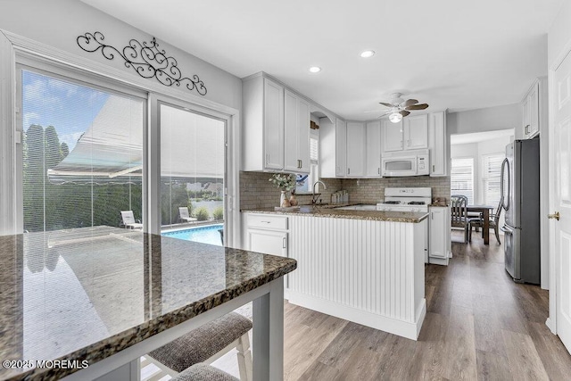 85 Mapletree Rd, Toms River, NJ 08753 - kitchen featuring white appliances, wood finished floors, a ceiling fan, stone countertops, and tasteful backsplash