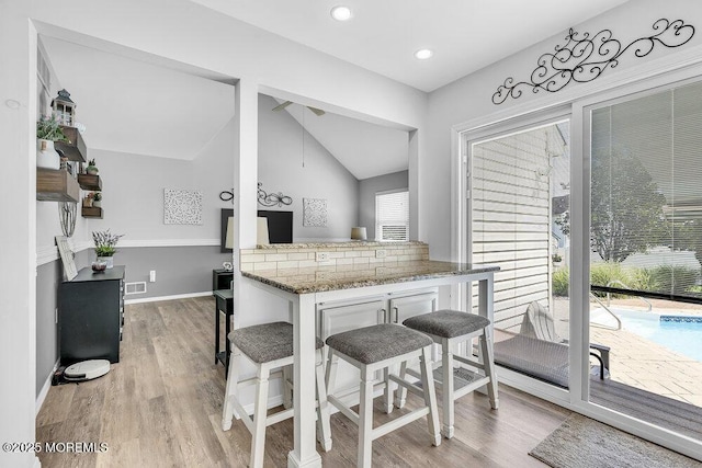 85 Mapletree Rd, Toms River, NJ 08753 - kitchen featuring light wood-type flooring, lofted ceiling, stone counters, white cabinets, and recessed lighting