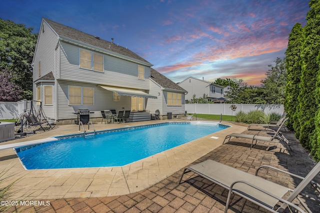 85 Mapletree Rd, Toms River, NJ 08753 - pool at dusk with a patio area, a fenced backyard, grilling area, and a diving board