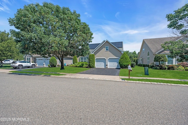 252 Enclave Blvd, Lakewood, NJ 08701 - view of front facade featuring driveway, a front yard, roof mounted solar panels, and an attached garage