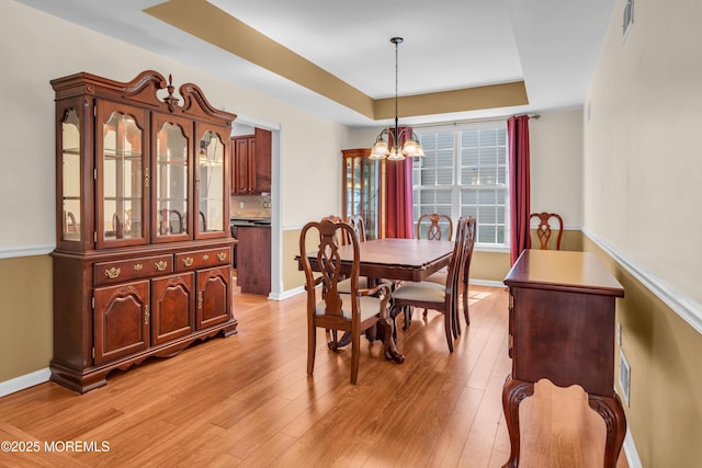 252 Enclave Blvd, Lakewood, NJ 08701 - dining space with a chandelier, a raised ceiling, and light wood finished floors
