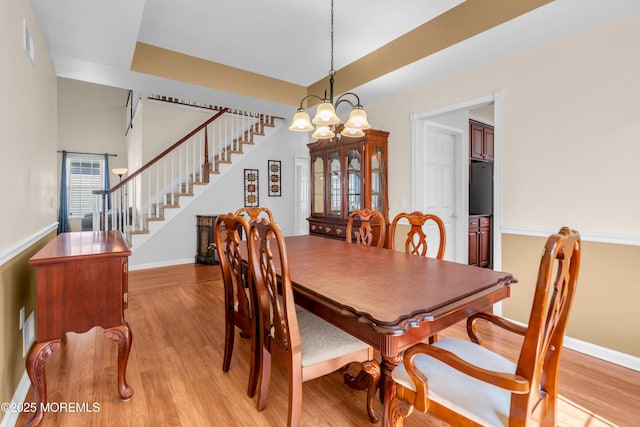 252 Enclave Blvd, Lakewood, NJ 08701 - dining room with stairs, light wood-style floors, and a chandelier