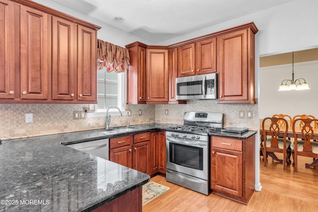 252 Enclave Blvd, Lakewood, NJ 08701 - kitchen with appliances with stainless steel finishes, a chandelier, light wood-style floors, and dark stone counters