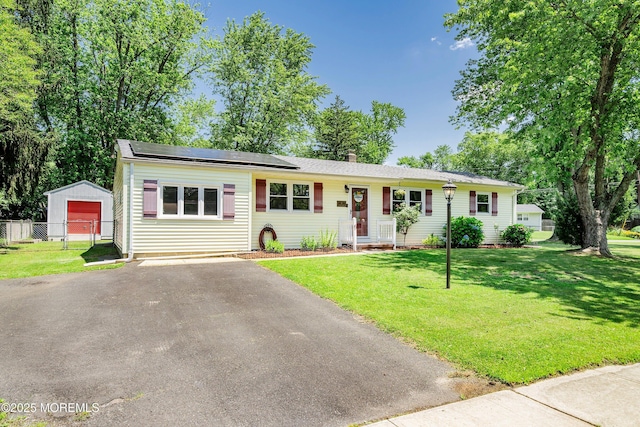 6 Redwood Rd, Howell, NJ 07731 - single story home with asphalt driveway, roof mounted solar panels, an outdoor structure, and a chimney