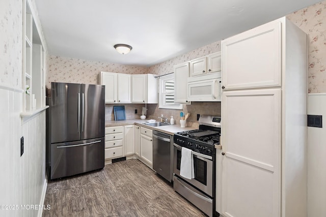 6 Redwood Rd, Howell, NJ 07731 - kitchen featuring appliances with stainless steel finishes, wallpapered walls, light countertops, white cabinets, and dark wood-type flooring