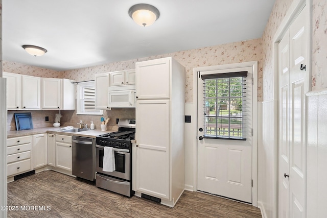 6 Redwood Rd, Howell, NJ 07731 - kitchen with stainless steel appliances, dark wood-style floors, wallpapered walls, white cabinets, and light countertops
