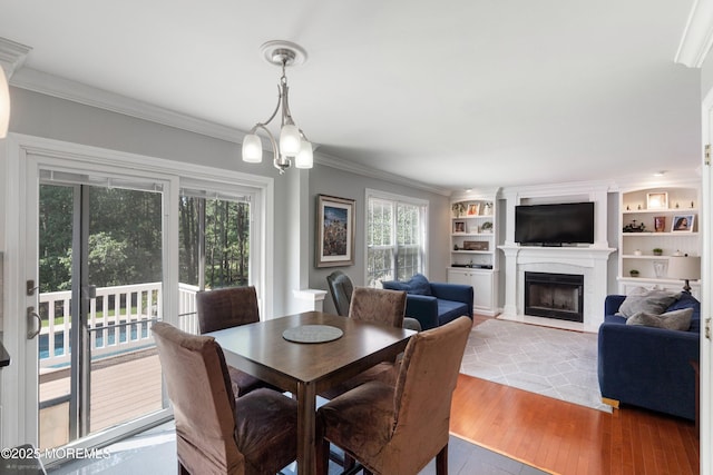 86 Lorelei Dr, Howell, NJ 07731 - dining room with a fireplace with flush hearth, crown molding, healthy amount of natural light, light wood-type flooring, and built in features