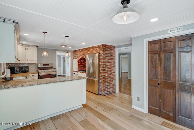 215 Parkertown Dr, Little Egg Harbor, NJ 08087 - kitchen featuring appliances with stainless steel finishes, light wood finished floors, a peninsula, light stone countertops, and recessed lighting