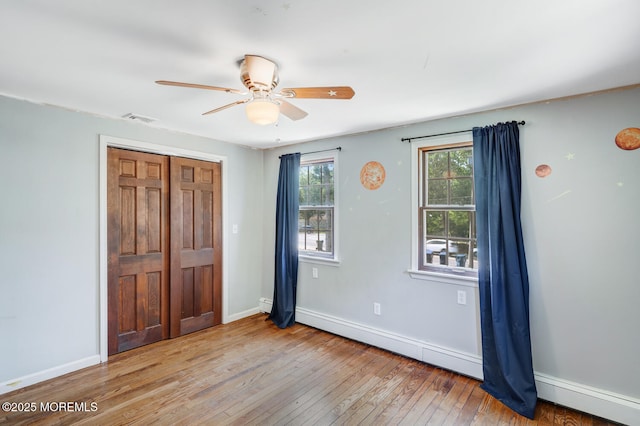 215 Parkertown Dr, Little Egg Harbor, NJ 08087 - unfurnished bedroom with a baseboard heating unit, hardwood / wood-style floors, and a ceiling fan