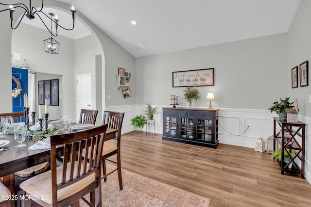 16 Vecchio Rd, Manchester, NJ 08759 - dining room with arched walkways, a chandelier, wood finished floors, a wainscoted wall, and high vaulted ceiling