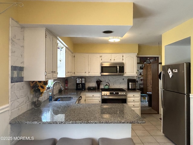 2711 2nd Ave, Toms River, NJ 08753 - kitchen featuring stainless steel appliances, a peninsula, backsplash, and dark stone countertops