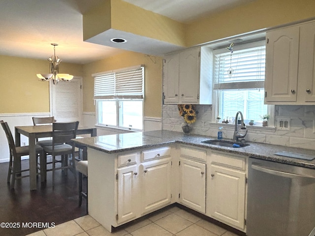 2711 2nd Ave, Toms River, NJ 08753 - kitchen featuring stainless steel dishwasher, a peninsula, a wainscoted wall, a chandelier, and white cabinets