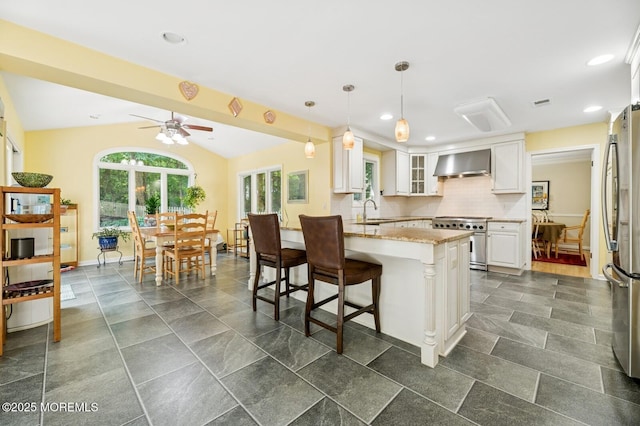 2 Derby Ln, East Brunswick, NJ 08816 - kitchen with stainless steel appliances, wall chimney exhaust hood, a breakfast bar area, white cabinetry, and ceiling fan
