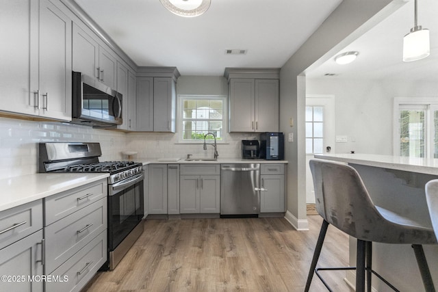 165 Tulip Ln, Freehold, NJ 07728 - kitchen with appliances with stainless steel finishes, gray cabinetry, light wood-type flooring, and light countertops