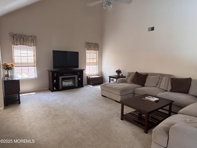 30 Gristmill Rd, Howell, NJ 07731 - living area with plenty of natural light, carpet flooring, high vaulted ceiling, a glass covered fireplace, and a ceiling fan
