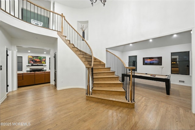 8 Shadowbrook Dr, Colts Neck, NJ 07722 - staircase with a high ceiling, wood finished floors, a fireplace, and recessed lighting