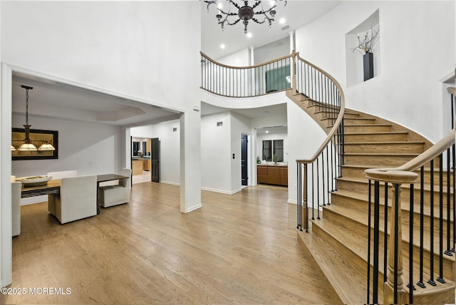 8 Shadowbrook Dr, Colts Neck, NJ 07722 - stairs featuring a chandelier, wood finished floors, and a high ceiling
