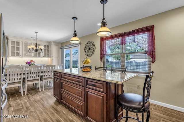 18 Laurel Crest Dr, Howell, NJ 07731 - kitchen featuring wood finished floors, decorative light fixtures, a chandelier, light stone counters, and glass insert cabinets