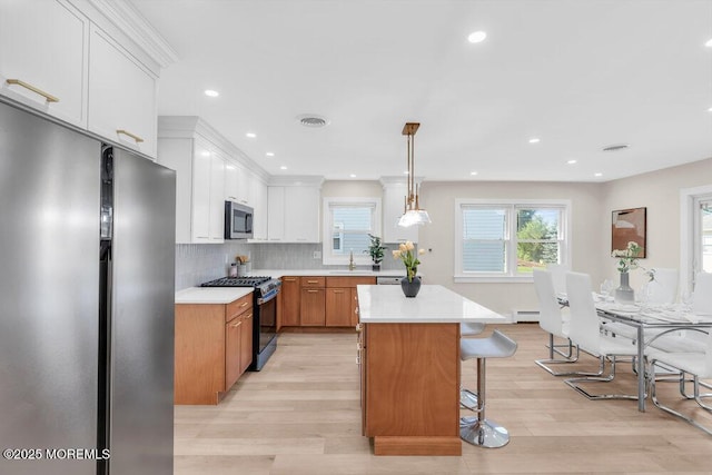 6 Fairfield Rd, Toms River, NJ 08757 - kitchen with appliances with stainless steel finishes, light countertops, a kitchen bar, light wood-type flooring, and a kitchen island